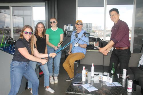 a gathering of people with golf clubs